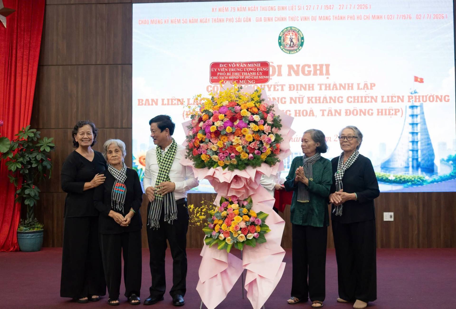 C&oacute; thể l&agrave; h&igrave;nh ảnh về một hoặc nhiều người, c&aacute;i bục v&agrave; văn bản cho biết 'KY UIỆM mAM NGAY THƯƠNG BINH LIET 112711 1 MUNGK NI&Ecirc;M50 N&Atilde;M NGAY &Tau;&Eta;&Delta;иH PHO S&Agrave;I G&Ocirc;N GIA DINH CHINH THỨC INH D DU MANG THANH PHO 1947 27/1 2026) CHI MINH 021 7/1976 02/ 217/2026 20261 D/C &nu;ώ&nu;&alpha;&iota; MINH BAN BANLI&Ecirc;N LIEN PHO ICHI HONDT NGHI MUNG HYET ĐINH THANH LAP NG NƯ KHANG CHI&Ecirc;N LIEN PHƯƠNG G HOA, T&Acirc;N Đ&Ocirc;NG HIỆP)'
